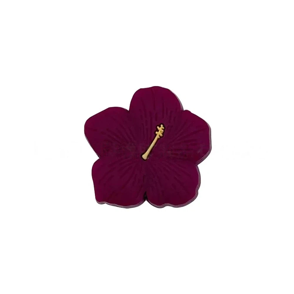 Assorted pastel and earthy tone hibiscus flower silicone focal beads with gold stamen detail displayed on a pink surface, available in colors including blue, purple, green, pink, mauve, brown, tan, yellow, and peach. - Burgundy
