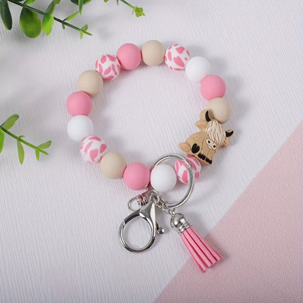 Highland cow silicone bead wristlet keychain bracelet with mint green, cream, white, and cow print beads, featuring a cute highland cow focal bead, lobster clasp, and teal and yellow tassels. - 3