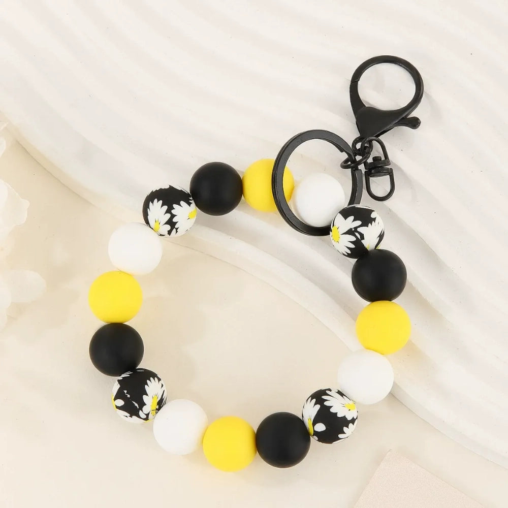 Four beaded silicone bead wristlet keychains featuring colorful jeep car printed silicone beads in red, teal, blue, and yellow with black and checkered beads and tassel accents. - Yellow