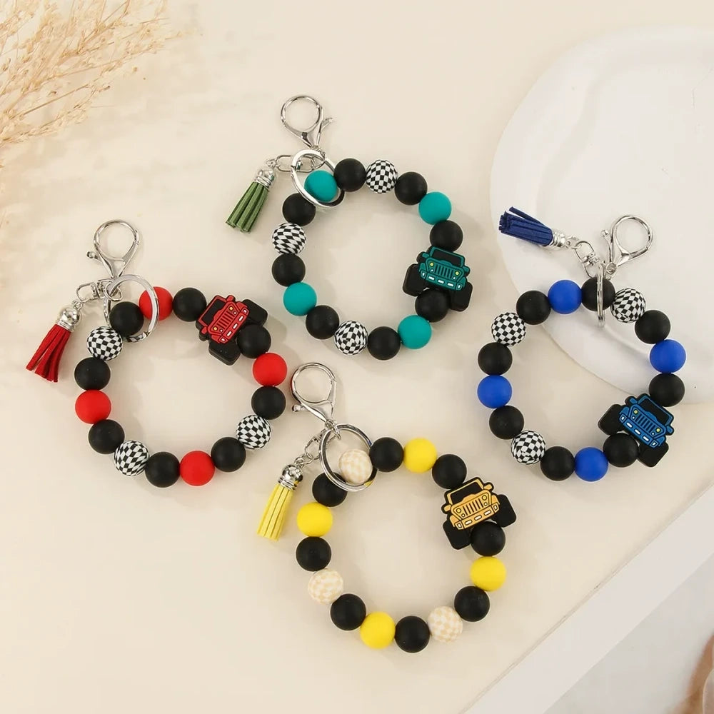 Four beaded bracelet keychains featuring jeep car silicone beads in red, teal, blue, and yellow with black and checkered beads and tassel accents on a white surface. - Random Mixed