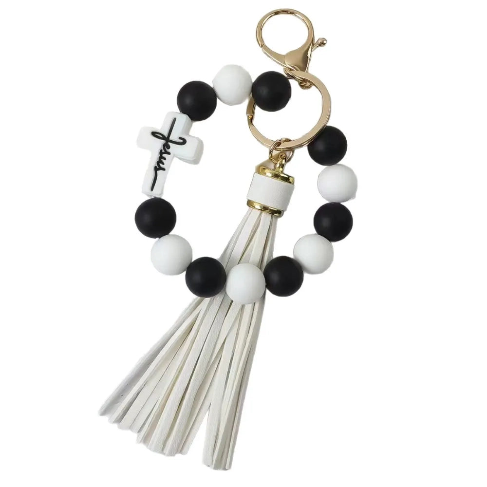 Colorful Jesus cross silicone bead stretch bracelets with tassel keychains in black, pink, purple, teal, and green color combinations on white background. - White