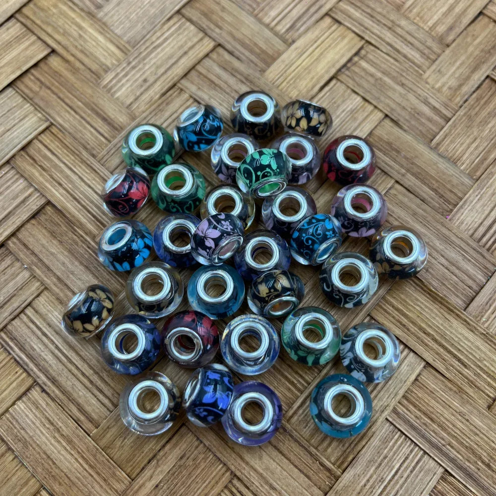 Assorted large hole acrylic bead spacers with mixed floral vine patterns in blue, purple, green, red, gray, and black