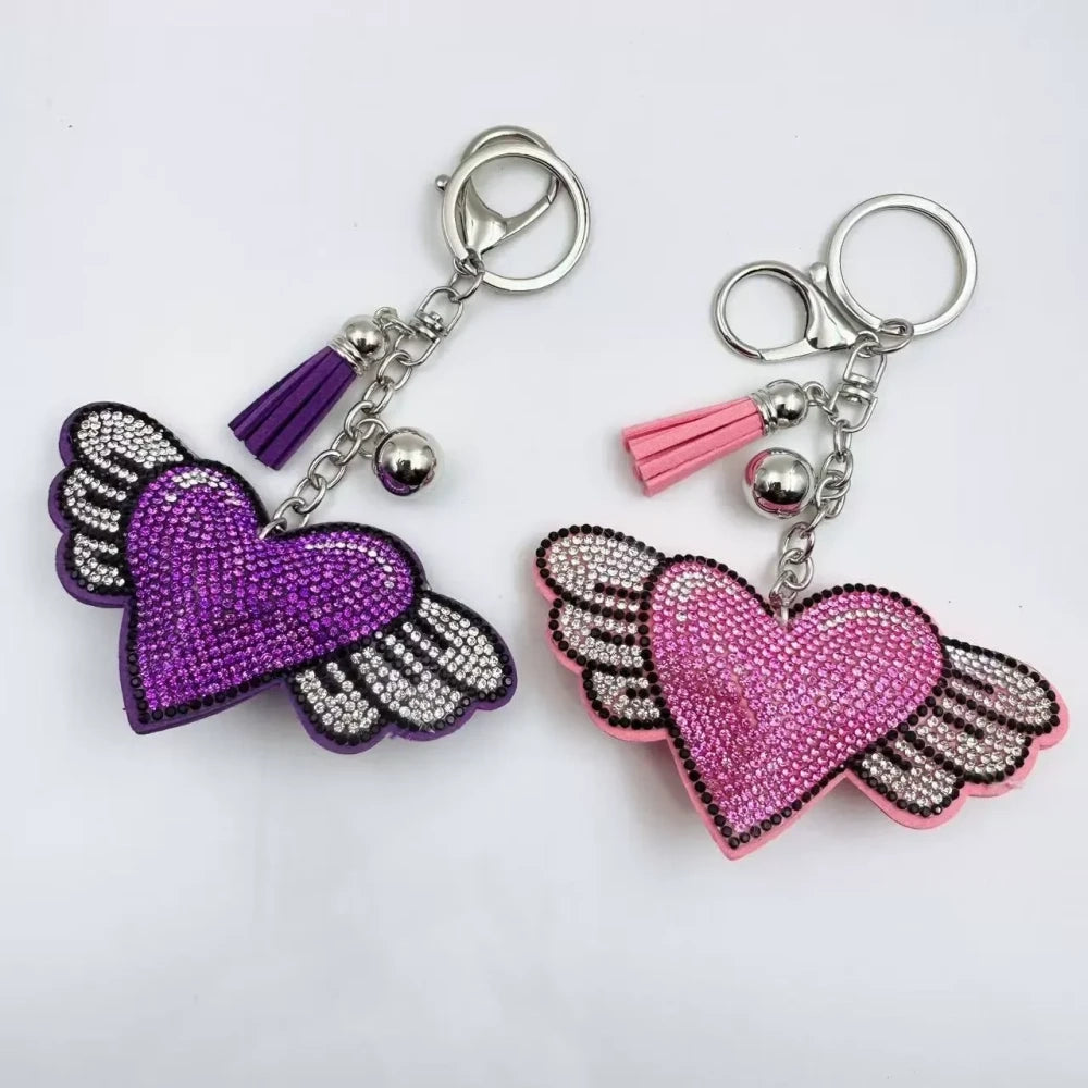 Purple and pink winged heart rhinestone charm beads with tassels, bells, and silver key rings on a white background - Random Mixed