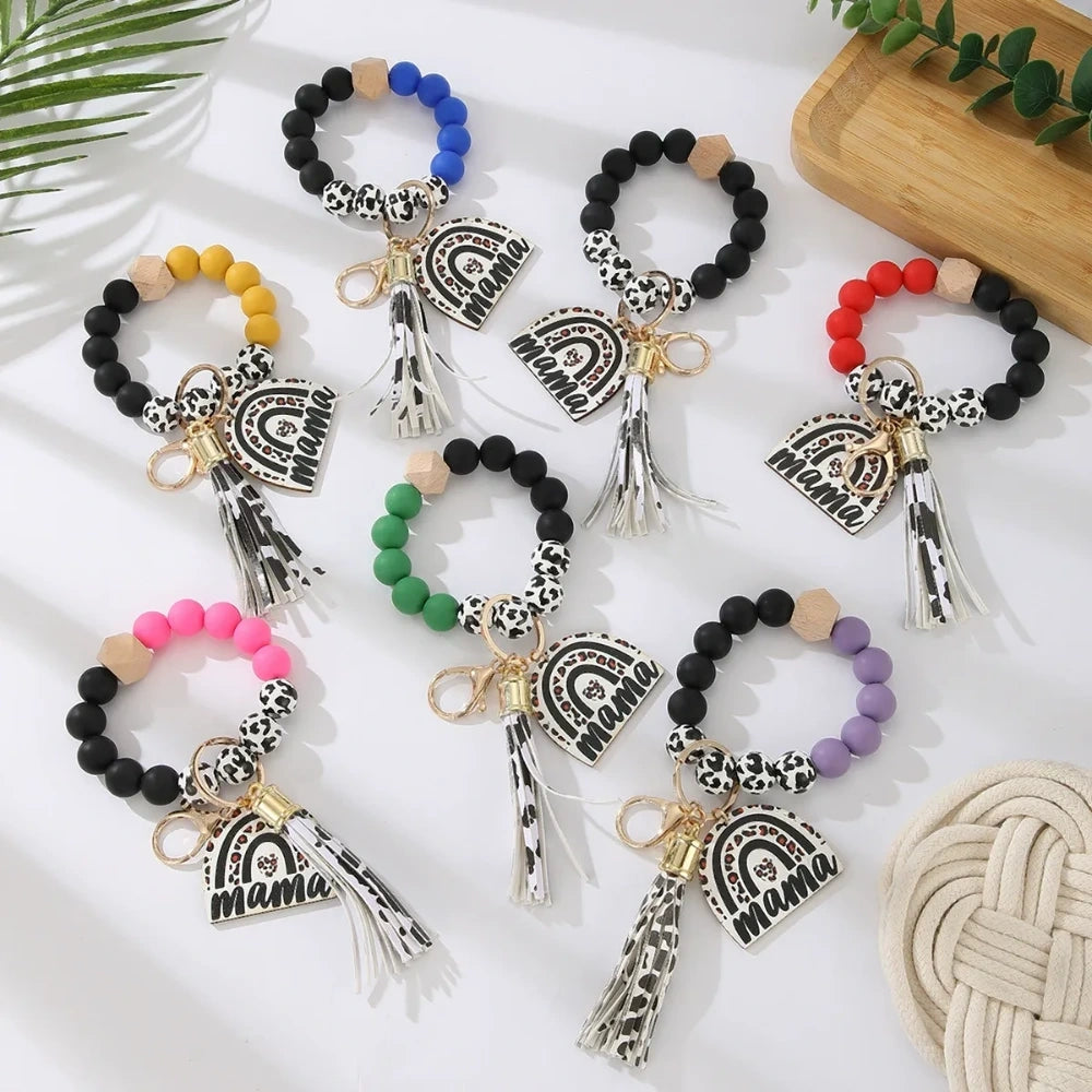 Set of 8 Mama rainbow leopard print silicone bead wristlet keychains with leather tassels and heart charm pendants in assorted colors including black, blue, yellow, green, pink, red, and purple on white background. - Random Mixed