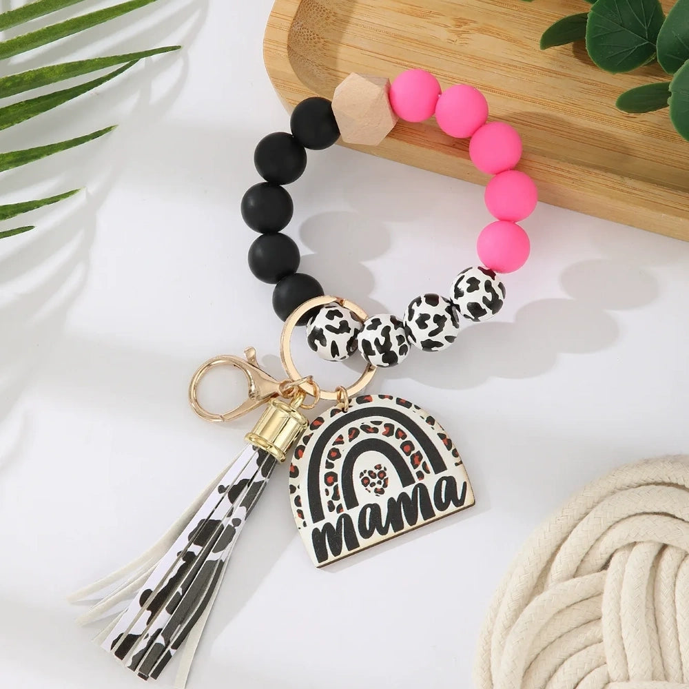 Set of 8 Mama rainbow leopard print silicone bead wristlet keychains with leather tassels and heart charm pendants in assorted colors including black, blue, yellow, green, pink, red, and purple on white background. - Rose Red