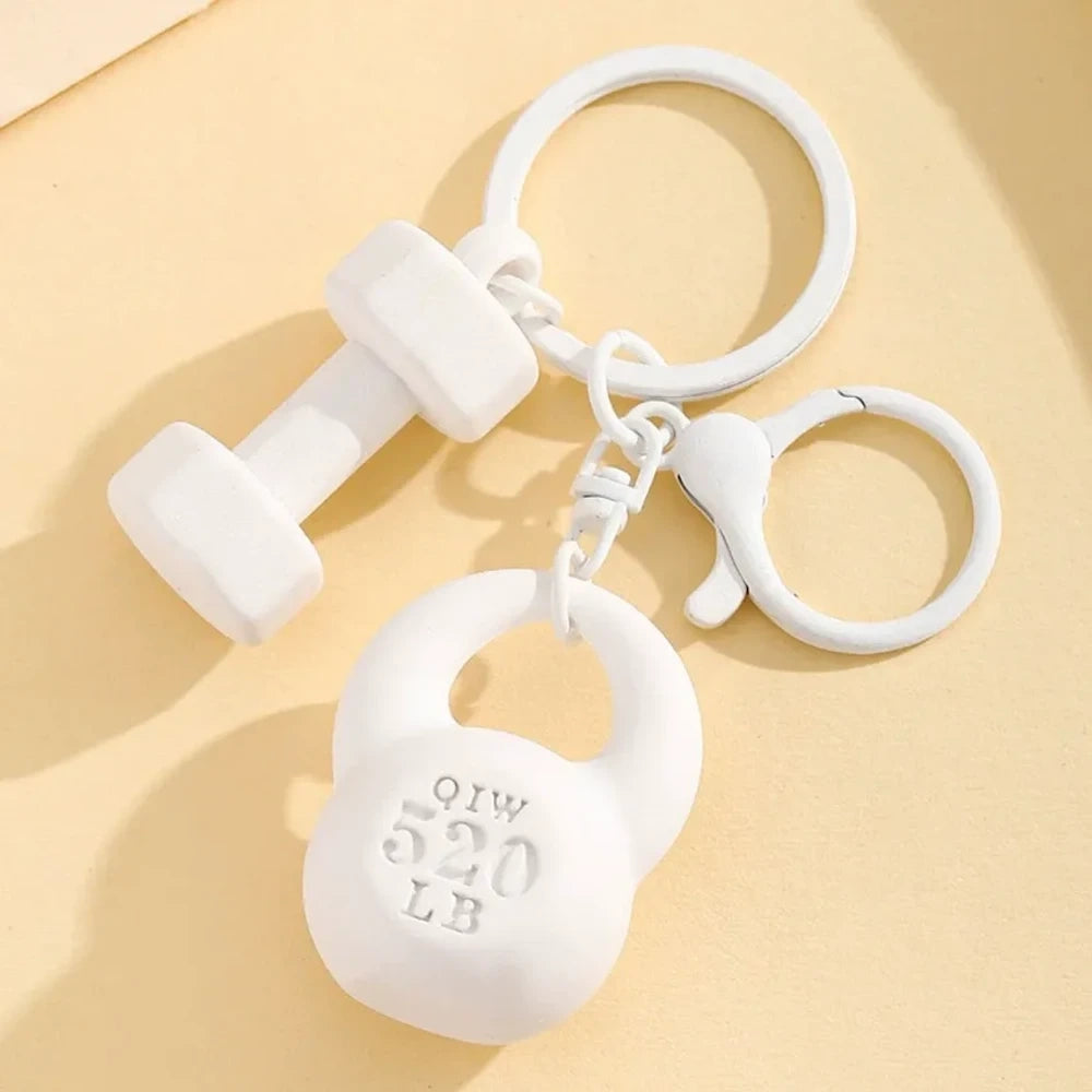 Set of colorful mini dumbbell and kettlebell keychain charms in red, pink, white, blue, black, purple, hot pink, and green, featuring 520 LB design, displayed on a yellow background. - White
