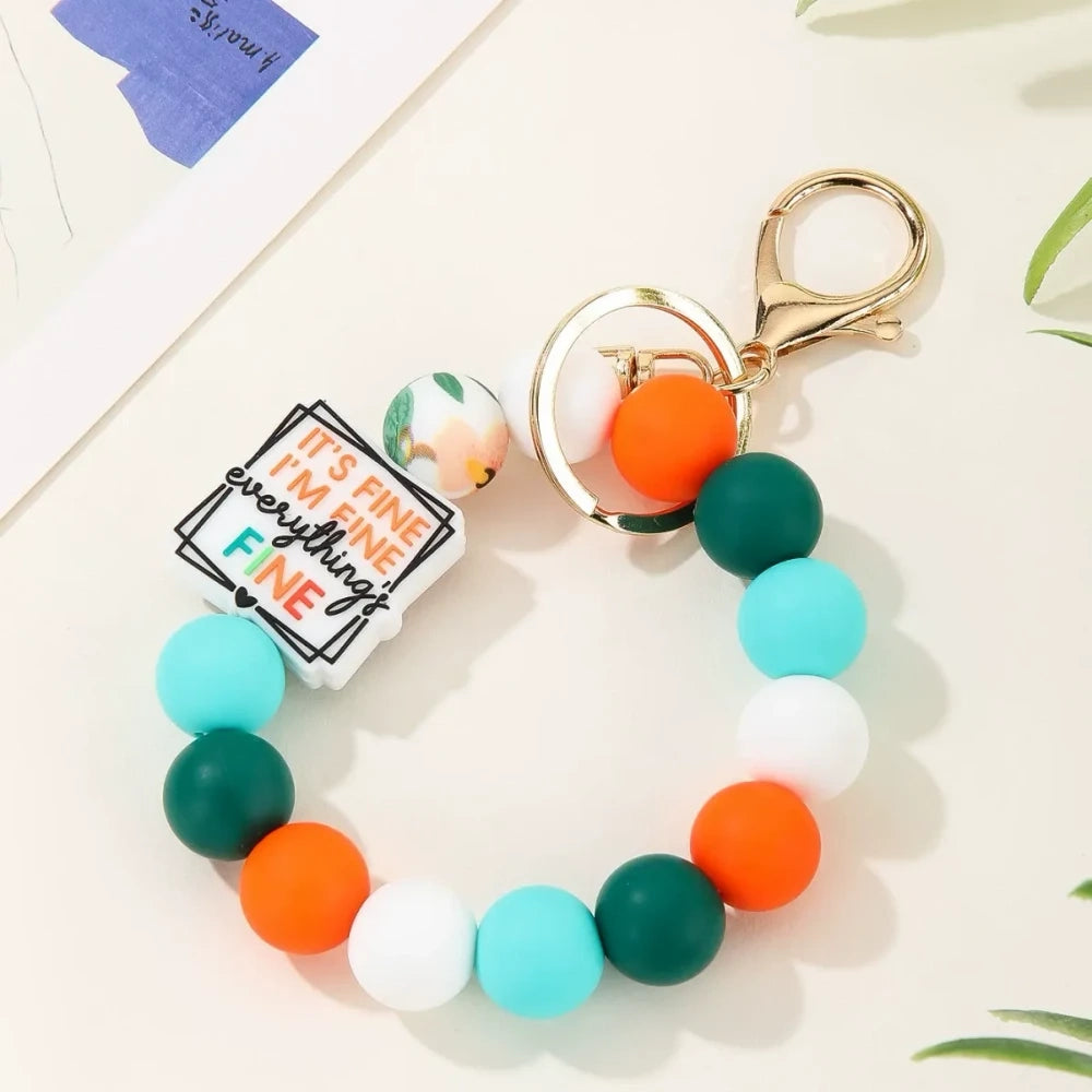 Colorful motivational quote printed silicone beads in pink, orange, teal, yellow and white used on beaded keychain bracelets with gold lobster clasp hardware - Green