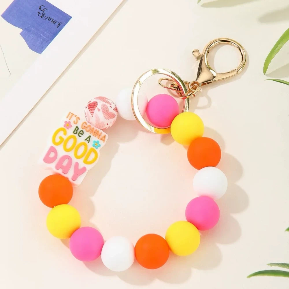 Colorful motivational quote printed silicone beads in pink, orange, teal, yellow and white used on beaded keychain bracelets with gold lobster clasp hardware - Red