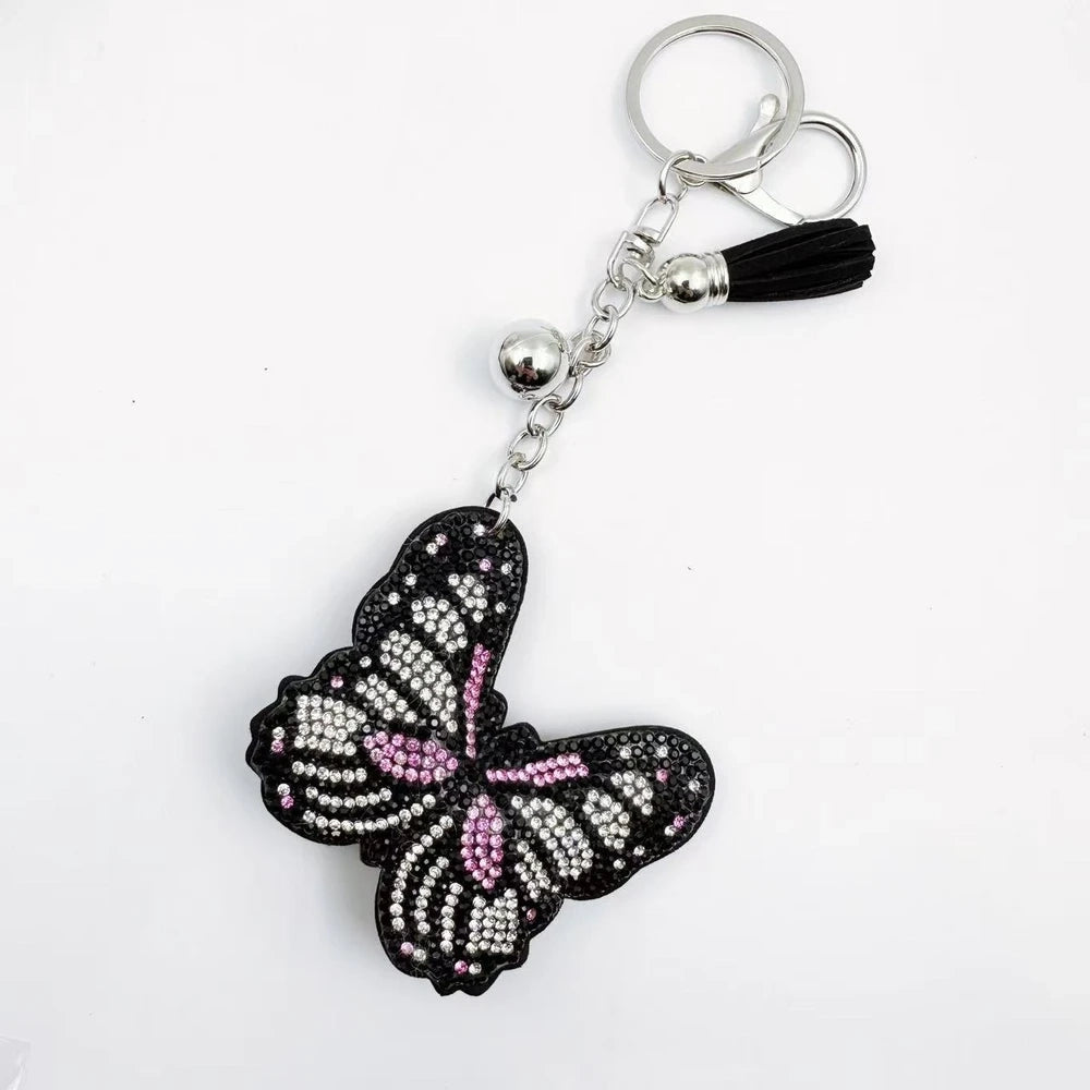 Two butterfly rhinestone fancy bead charms with black backing, pink accents, silver hardware, and tassels on a white background. - 2