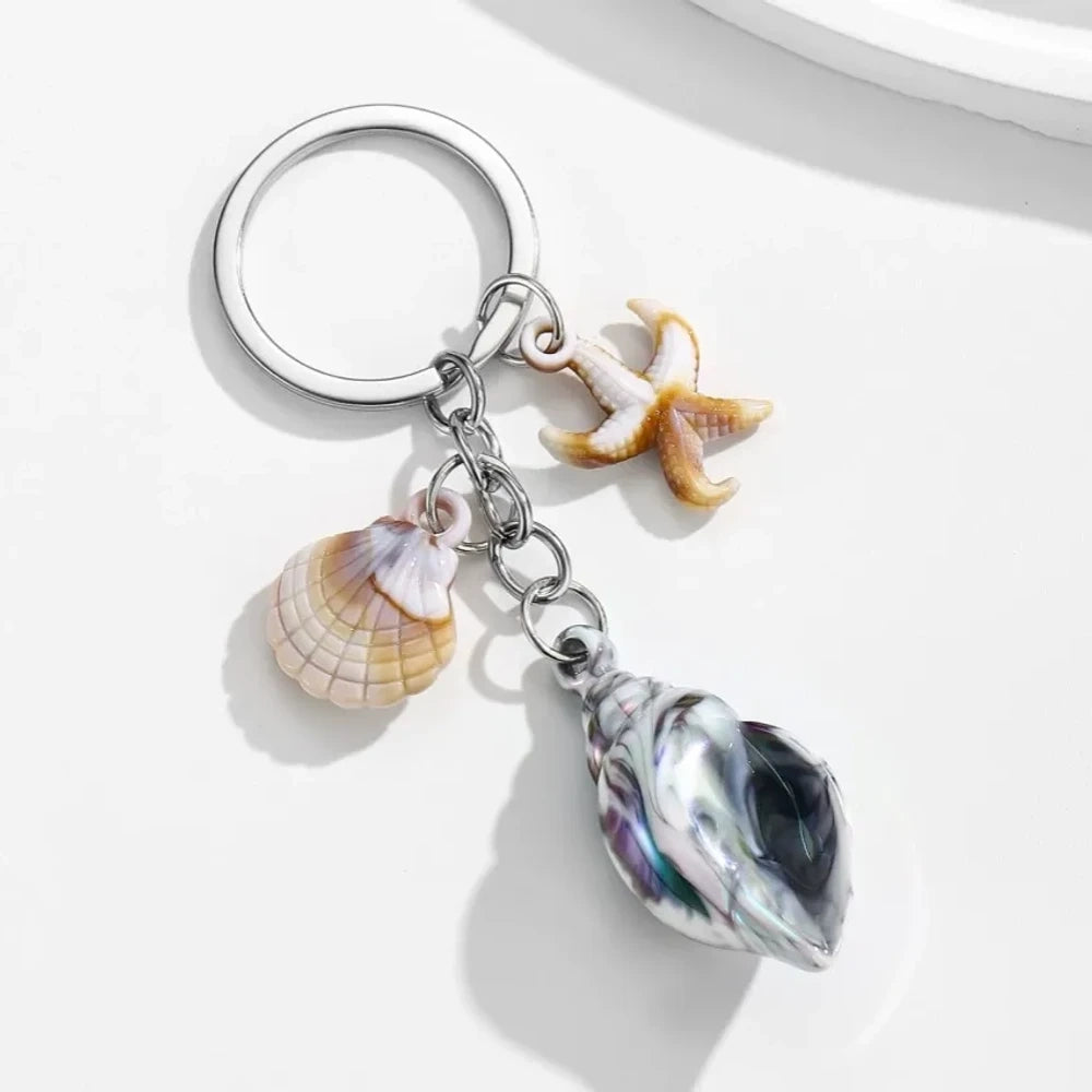 8 colorful ocean-themed resin conch shell charm keychains with starfish and scallop shell pendants on silver rings in blue, pink, purple, rainbow, and brown tones. - White-Black