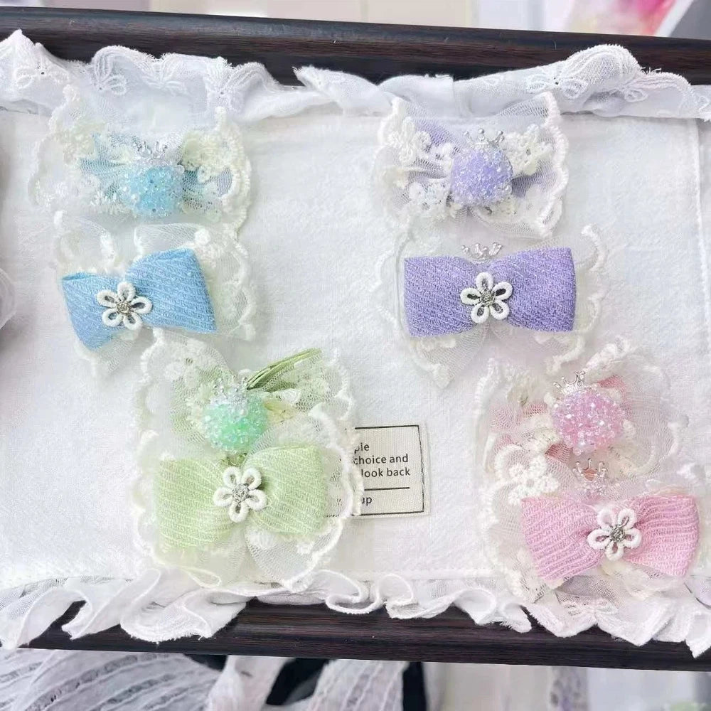 Assorted pastel lace bow fancy beads with floral rhinestone centers in blue, purple, green, and pink displayed on a white lace-trimmed tray for DIY jewelry making and beadable pens.