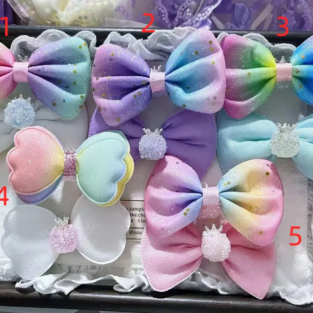 Five pastel rainbow gradient glitter bow hair clip fancy beads with crown and heart embellishments in purple, blue, pink and multicolor, numbered 1 through 5, displayed in a decorative box for DIY jewelry making and beadable pens.