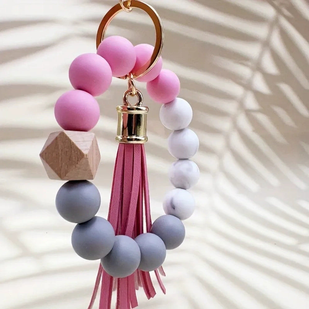 Set of 4 pastel silicone bead bracelet keychains with leather tassels in pink, blue, purple, and mint green, featuring marble and wood accent beads with gold lobster clasp hardware. - 1