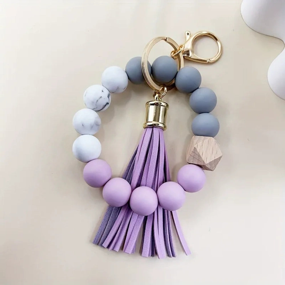 Set of 4 pastel silicone bead bracelet keychains with leather tassels in pink, blue, purple, and mint green, featuring marble and wood accent beads with gold lobster clasp hardware. - 2