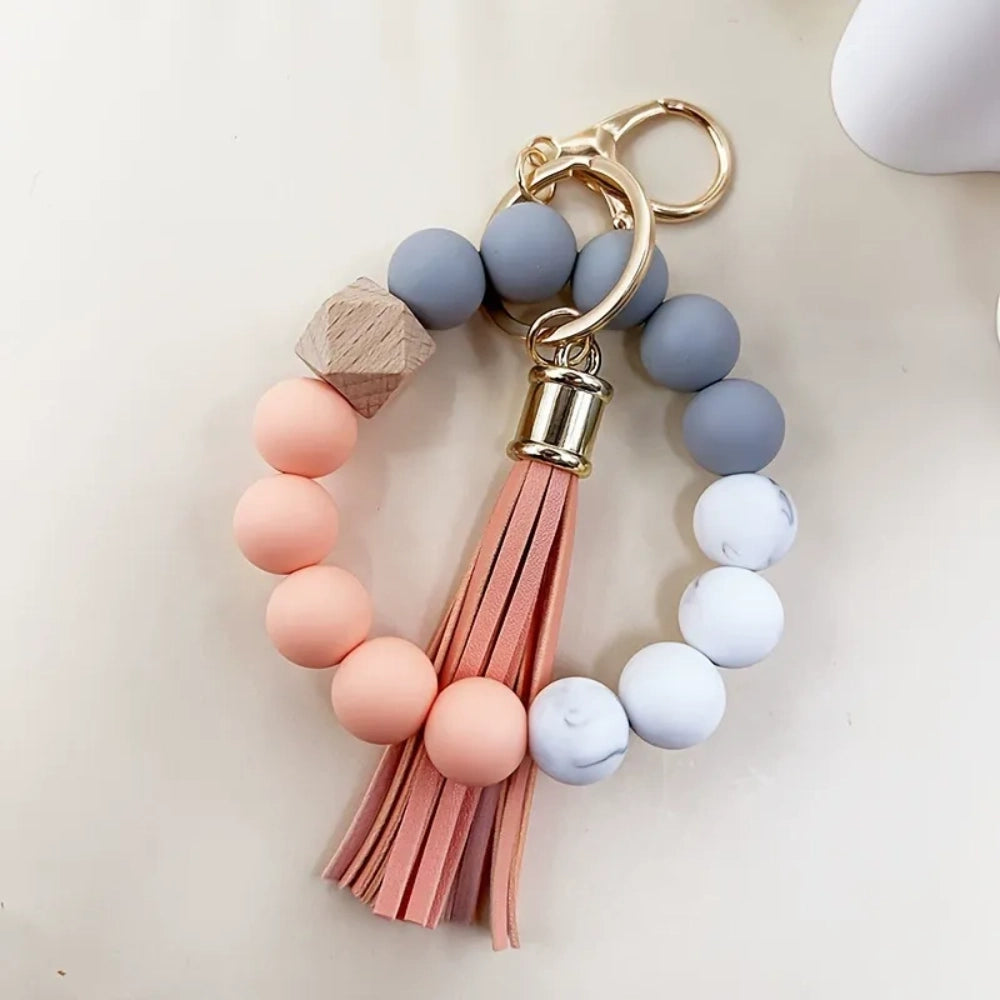 Set of 4 pastel silicone bead bracelet keychains with leather tassels in pink, blue, purple, and mint green, featuring marble and wood accent beads with gold lobster clasp hardware. - 3