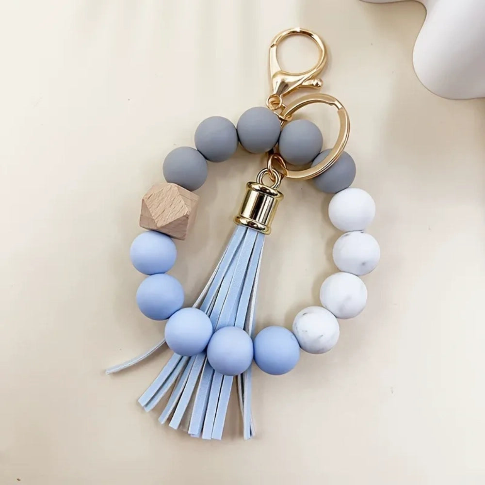 Set of 4 pastel silicone bead bracelet keychains with leather tassels in pink, blue, purple, and mint green, featuring marble and wood accent beads with gold lobster clasp hardware. - 4