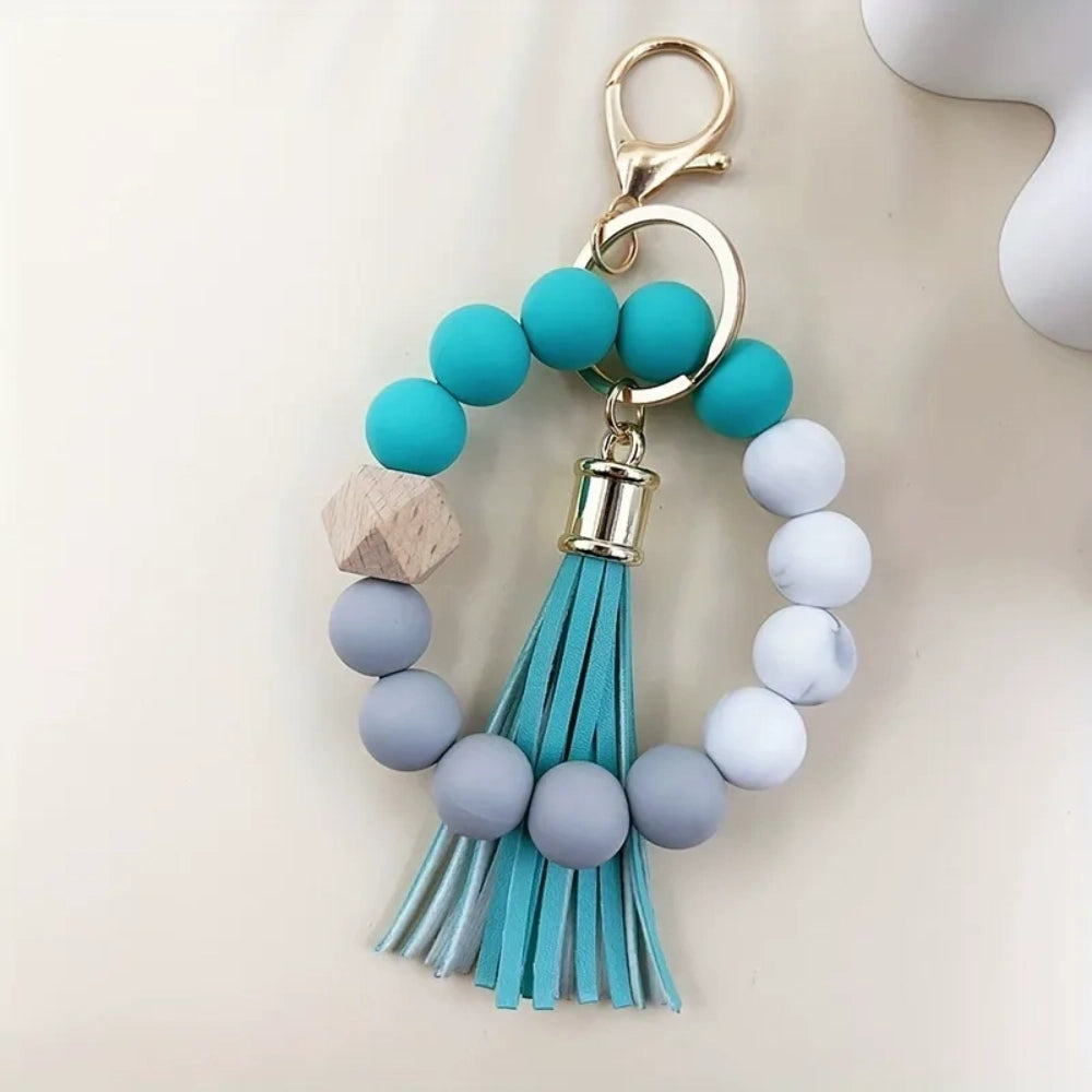 Set of 4 pastel silicone bead bracelet keychains with leather tassels in pink, blue, purple, and mint green, featuring marble and wood accent beads with gold lobster clasp hardware. - 5