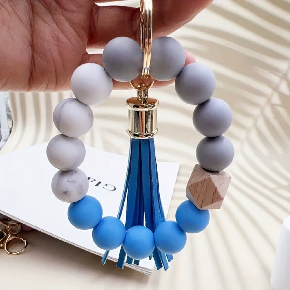 Set of 4 pastel silicone bead bracelet keychains with leather tassels in pink, blue, purple, and mint green, featuring marble and wood accent beads with gold lobster clasp hardware. - 6