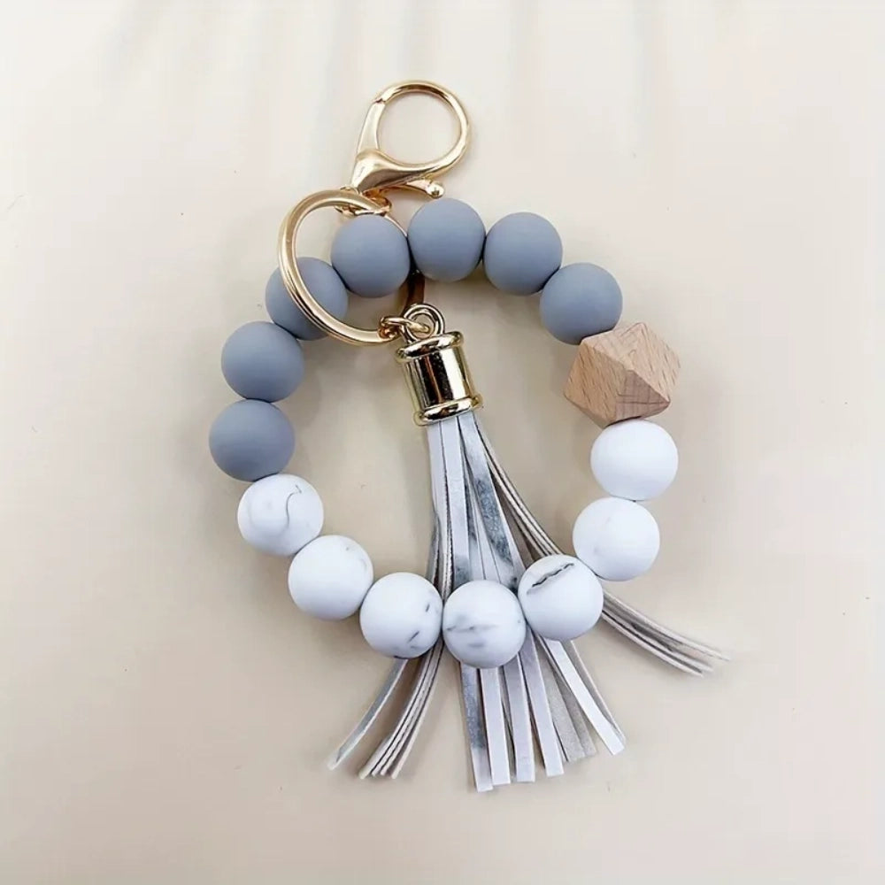 Set of 4 pastel silicone bead bracelet keychains with leather tassels in pink, blue, purple, and mint green, featuring marble and wood accent beads with gold lobster clasp hardware. - 8