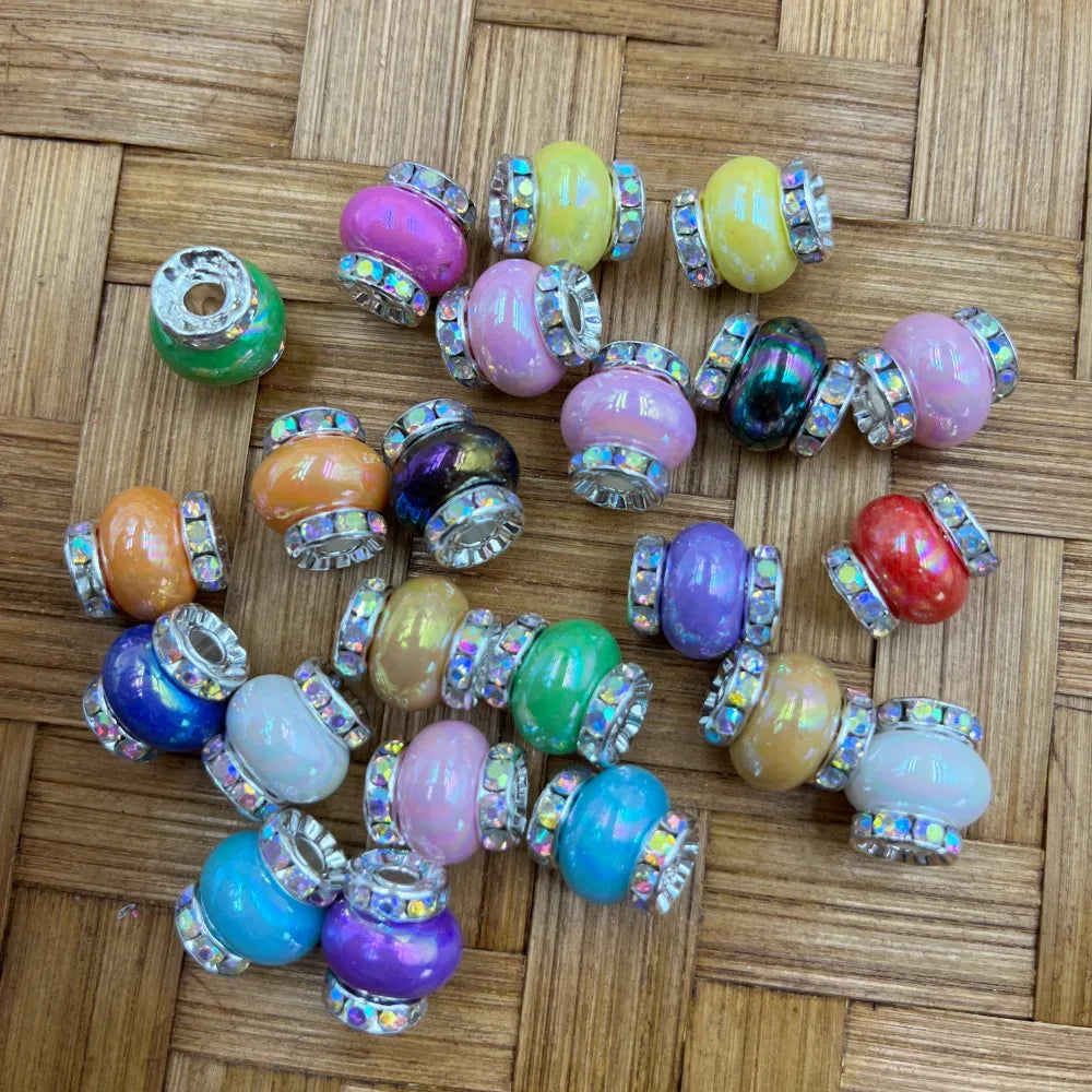 Assorted colorful acrylic spacer beads with silver rhinestone edges in pastel and vivid rainbow colors on a wicker background, perfect for beadable pens, keychains, badge reels, and DIY jewelry making.