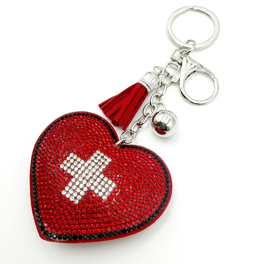 Red rhinestone heart-shaped keychain with white crystal cross design, red tassel, silver ball charm, and silver key rings on white background