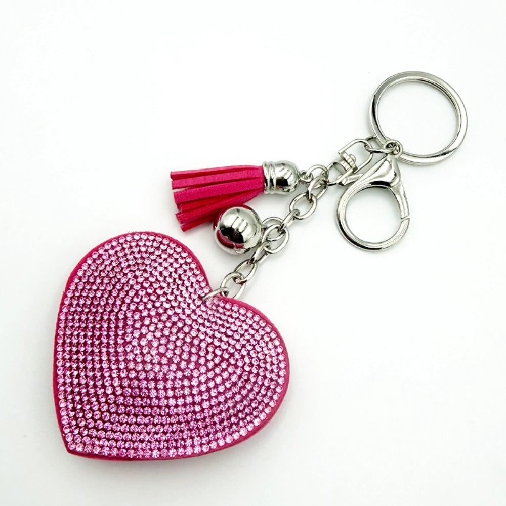 Assorted rhinestone crystal heart-shaped keychains with colorful tassels and lobster clasp in silver and gold tones, available in pink, red, green, yellow, silver, and magenta. - Pink