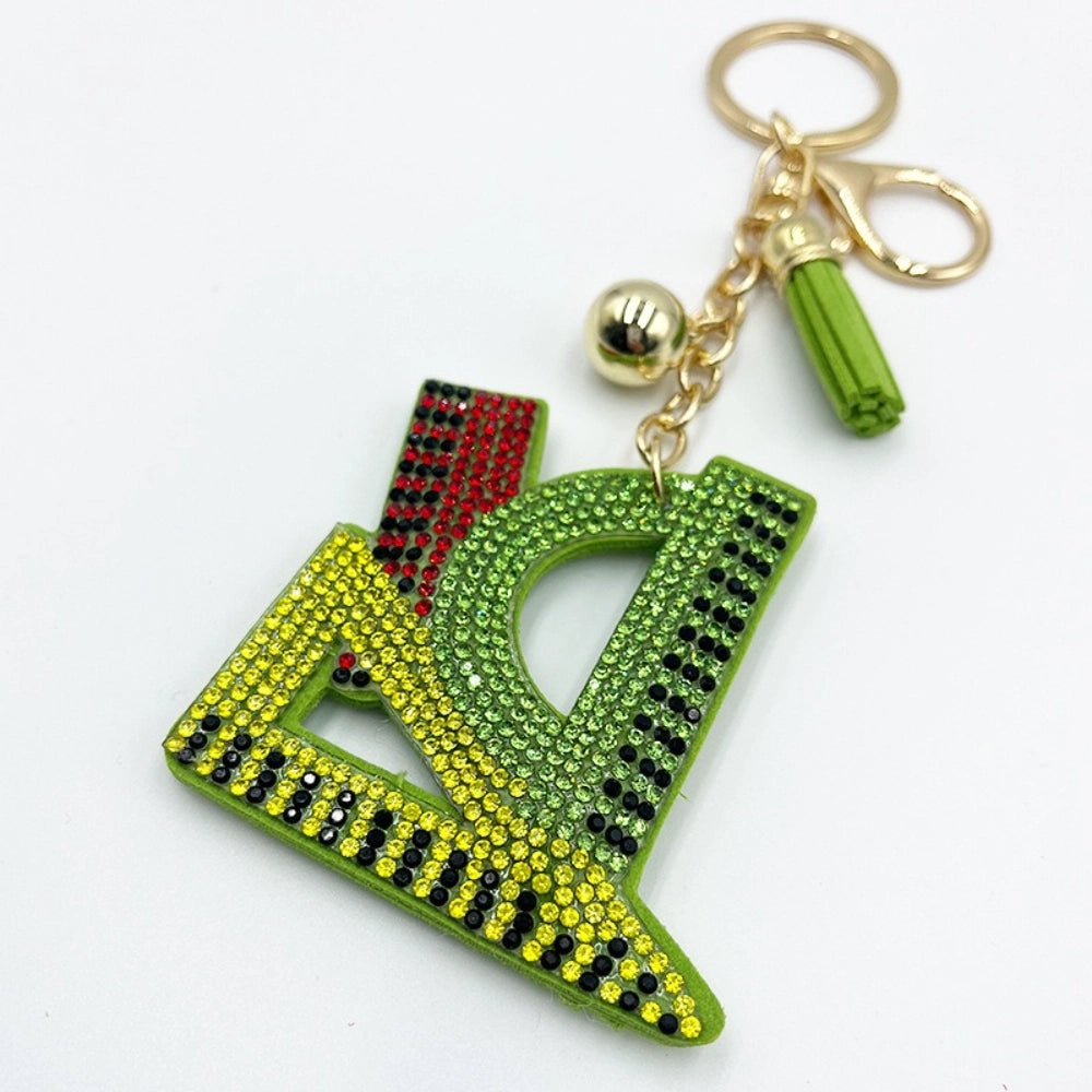 Green yellow and red rhinestone crystal Libra zodiac scale keychain charm with gold hardware and green tassel on white background