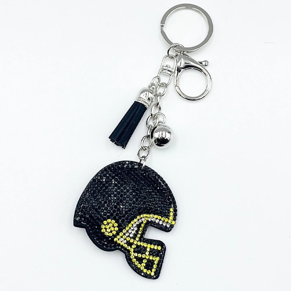 Five rhinestone-covered football helmet keychain charms in green, orange, black, blue, and purple with tassel and bell accents on silver key rings - Black
