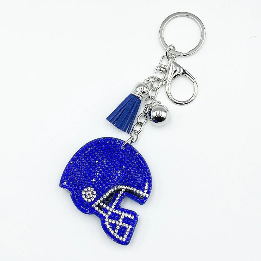 Five rhinestone-covered football helmet keychain charms in green, orange, black, blue, and purple with tassel and bell accents on silver key rings - Blue