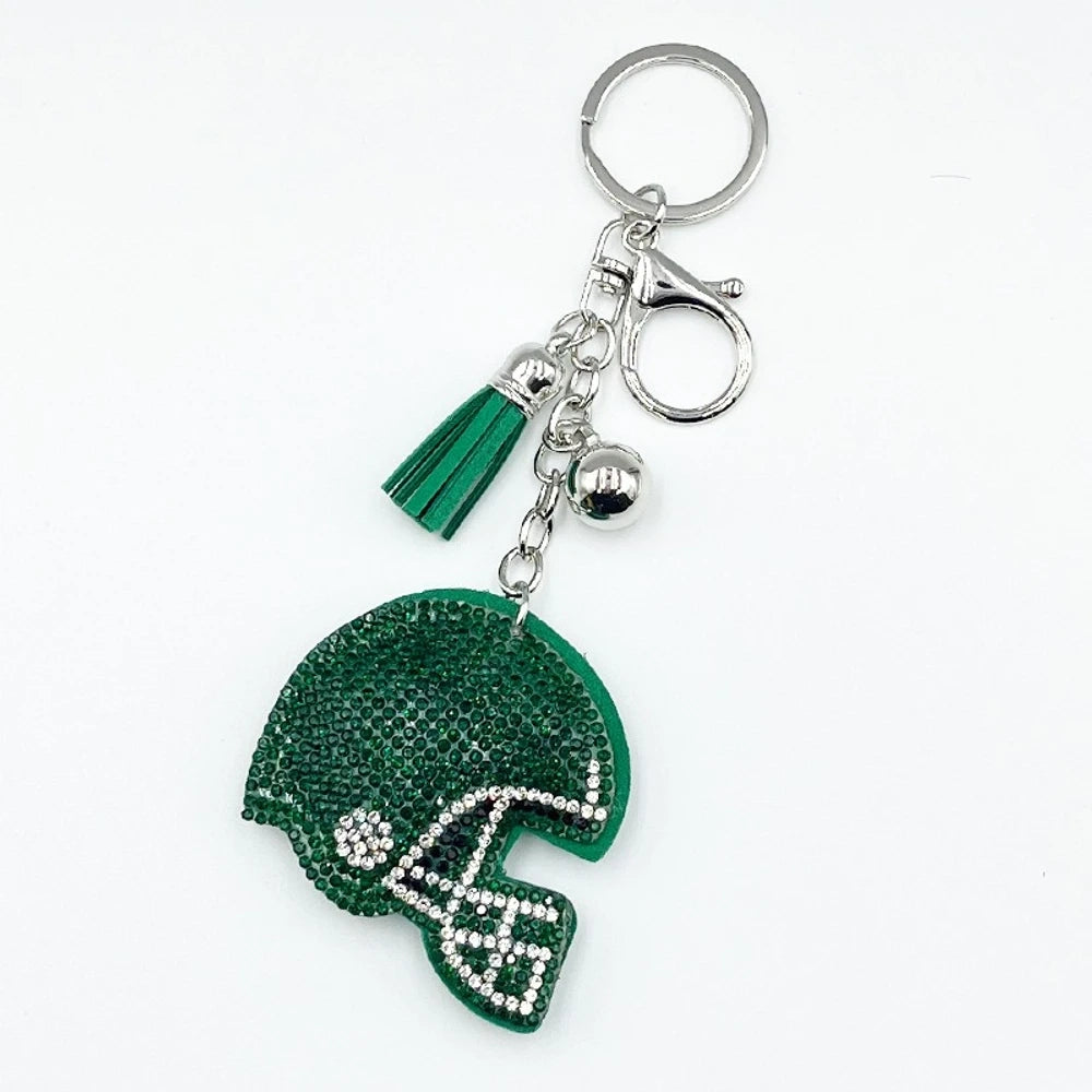 Five rhinestone-covered football helmet keychain charms in green, orange, black, blue, and purple with tassel and bell accents on silver key rings - Green