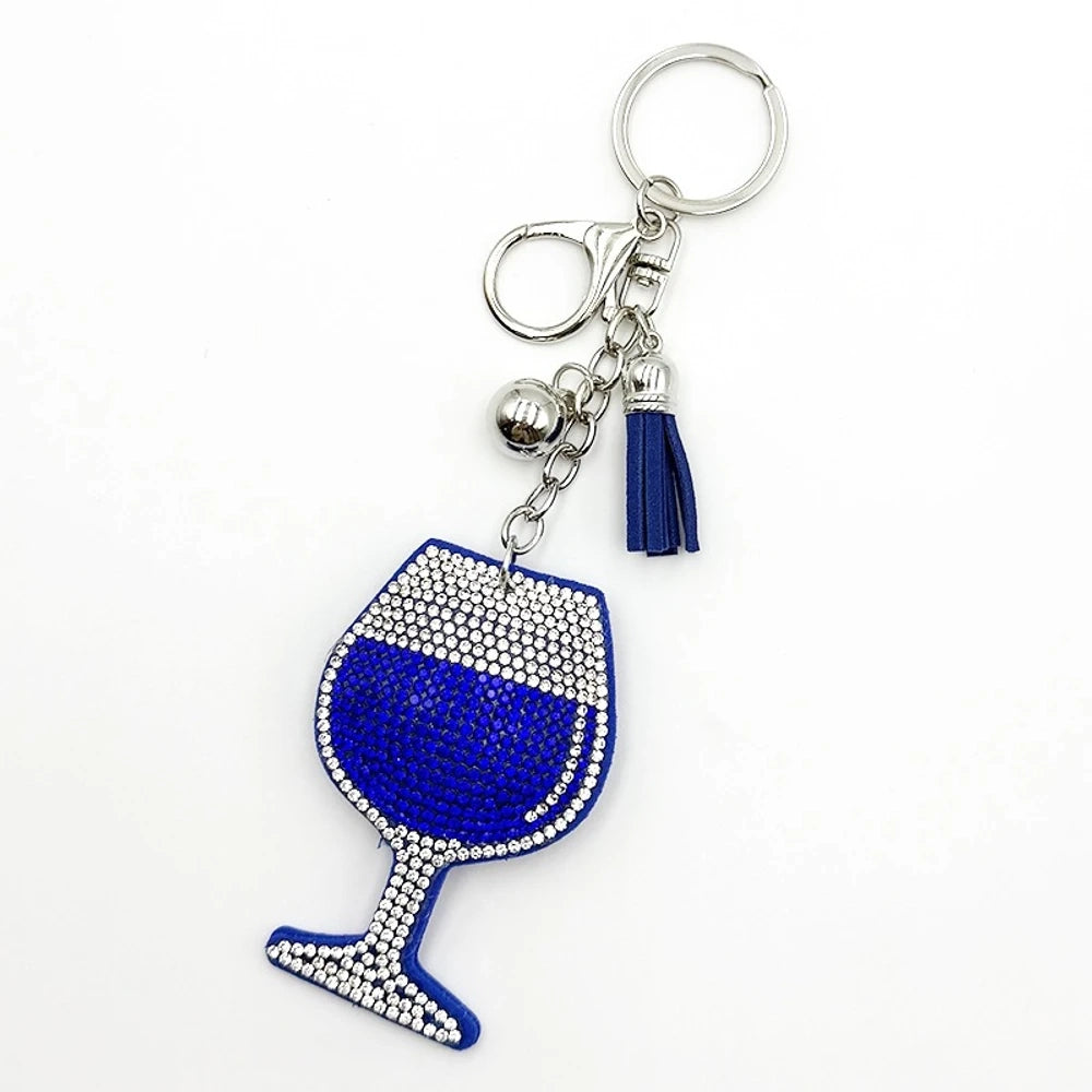Four rhinestone-covered wine glass keychain charms in red, pink, blue, and black with matching tassels and silver bell accents on white background. - Blue