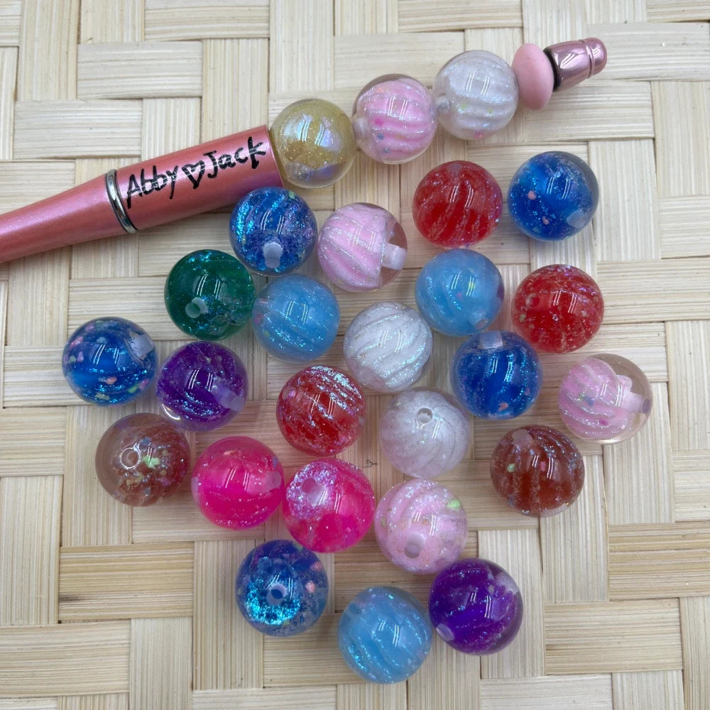 Assorted round acrylic beads with galaxy swirl glitter finish in pink, blue, red, purple, and pastel colors