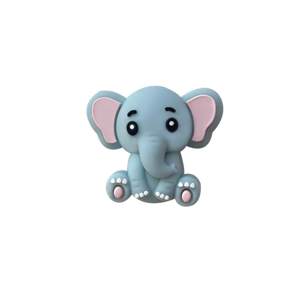 Five cute 3D baby elephant silicone focal beads in light gray, medium gray, dark gray, blue, and pink colors, sitting posed with pink inner ears and toenails, displayed on a white platform against a warm beige background. - Blue
