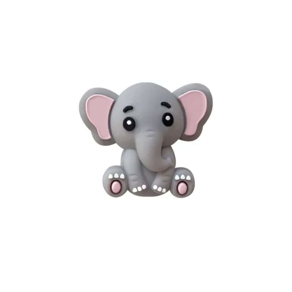 Five cute 3D baby elephant silicone focal beads in light gray, medium gray, dark gray, blue, and pink colors, sitting posed with pink inner ears and toenails, displayed on a white platform against a warm beige background. - Light Gray