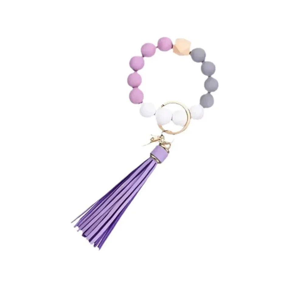 Set of 6 silicone bead wristlet keychains with colorful leather tassels in purple, blue, pink, gray, blush, and black on gold swivel clasps for DIY jewelry making. - 1