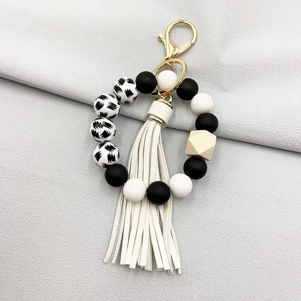 Set of 6 silicone bead wristlet keychains with colorful leather tassels in purple, blue, pink, gray, blush, and black on gold swivel clasps for DIY jewelry making. - 5