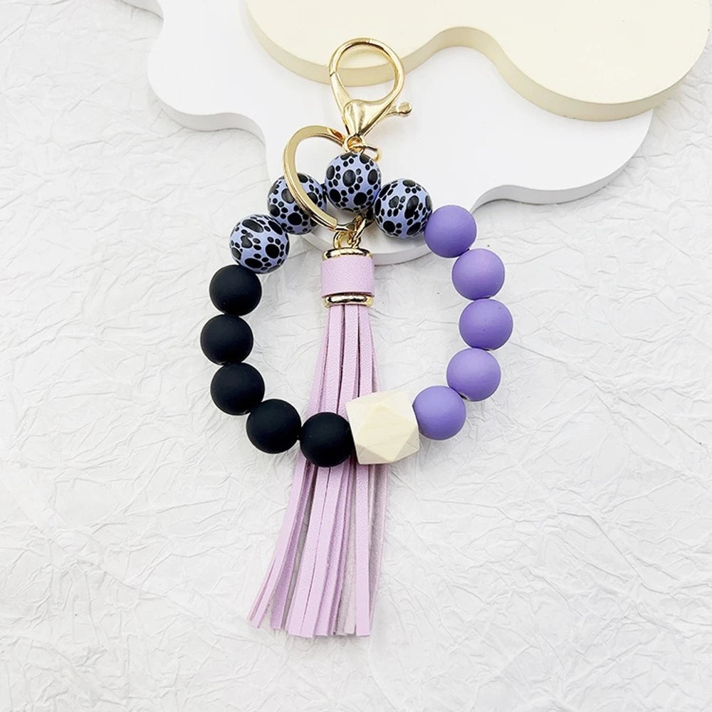 Set of 6 silicone bead wristlet keychains with colorful leather tassels in purple, blue, pink, gray, blush, and black on gold swivel clasps for DIY jewelry making. - 7