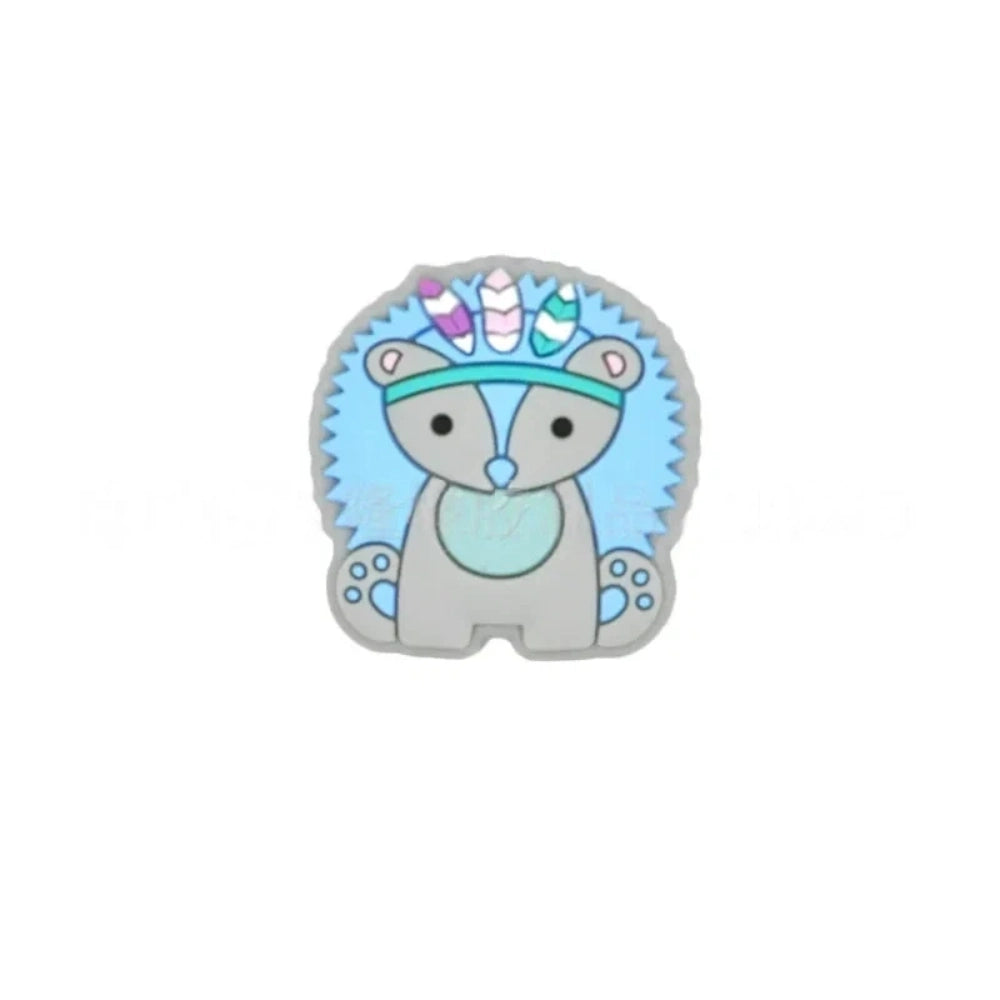 Five boho tribal animal silicone focal beads in pink, blue, yellow, brown, and gray featuring hedgehog, elephant, and lion characters wearing feathered headbands, displayed on a white background. - Blue