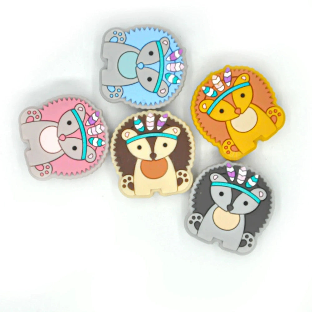 Five boho tribal animal silicone focal beads in pink, blue, yellow, brown, and gray featuring hedgehog, elephant, and lion characters wearing feathered headbands, displayed on a white background. - Random Mixed