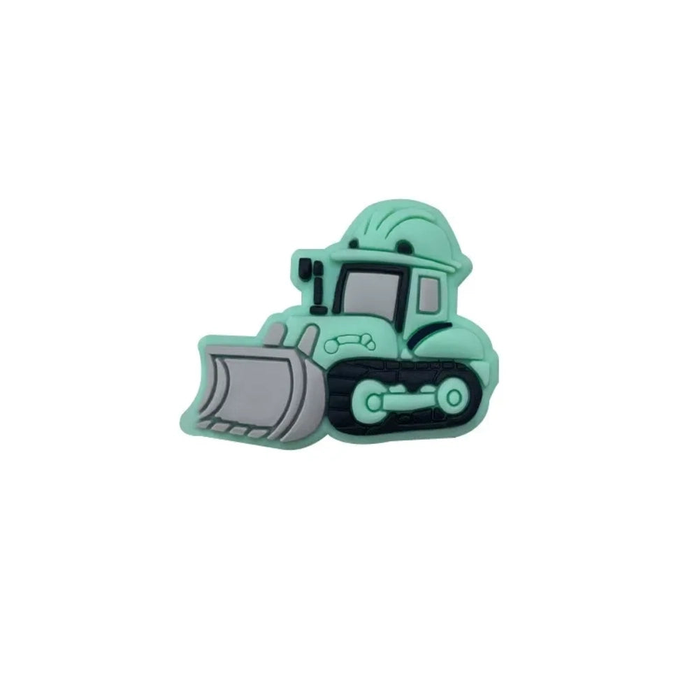 Five colorful silicone bulldozer construction truck focal beads in yellow, dark yellow, orange, blue, and mint green displayed on a white round platform - Green