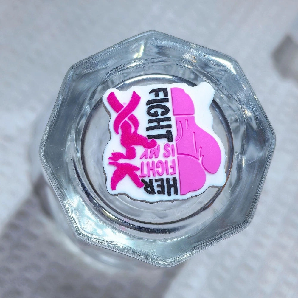 Silicone 3D focal beads in cancer awareness designs including pink and blue awareness ribbons, decorative bows, and 'Her Fight Is My Fight' charms displayed alongside completed beadable pens on a white textured background. - 4