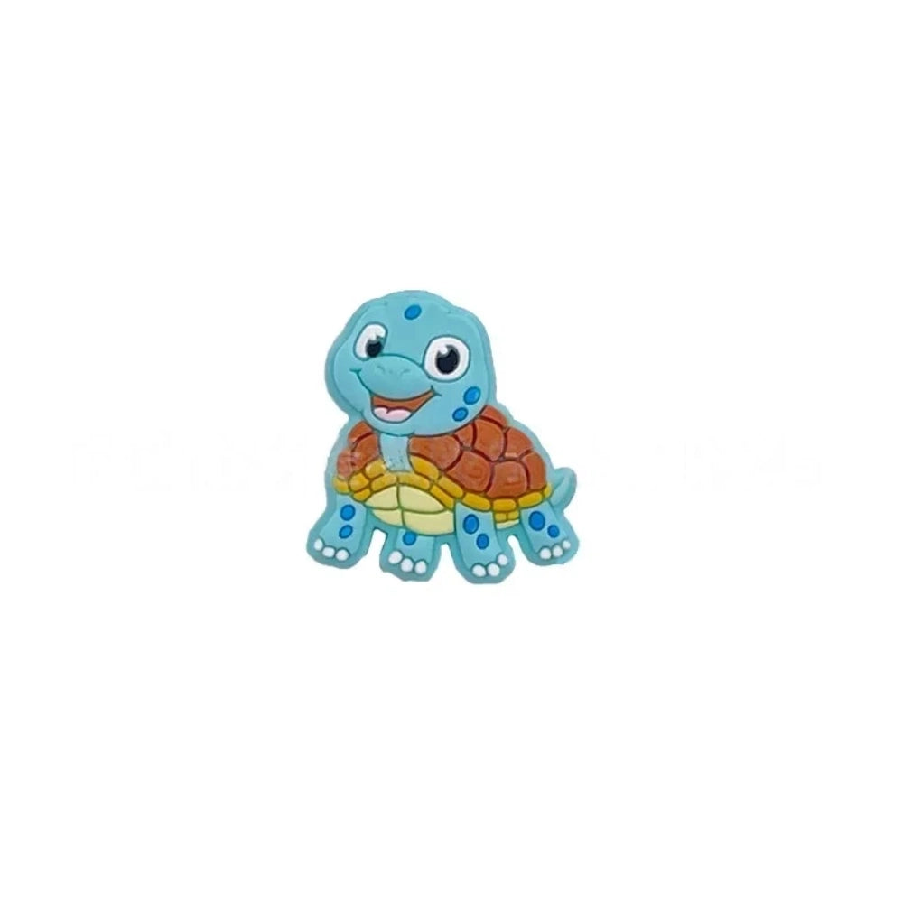 Cartoon turtle silicone focal beads in green, blue, yellow, and pink colors displayed on white pedestals against a pink background, available in large and small sizes for DIY crafts. - Blue