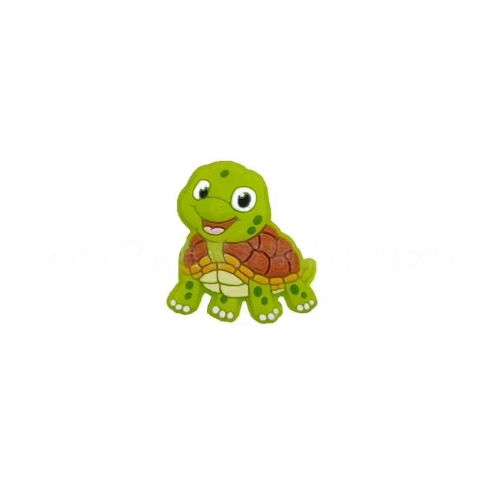 Cartoon turtle silicone focal beads in green, blue, yellow, and pink colors displayed on white pedestals against a pink background, available in large and small sizes for DIY crafts. - Grass Green