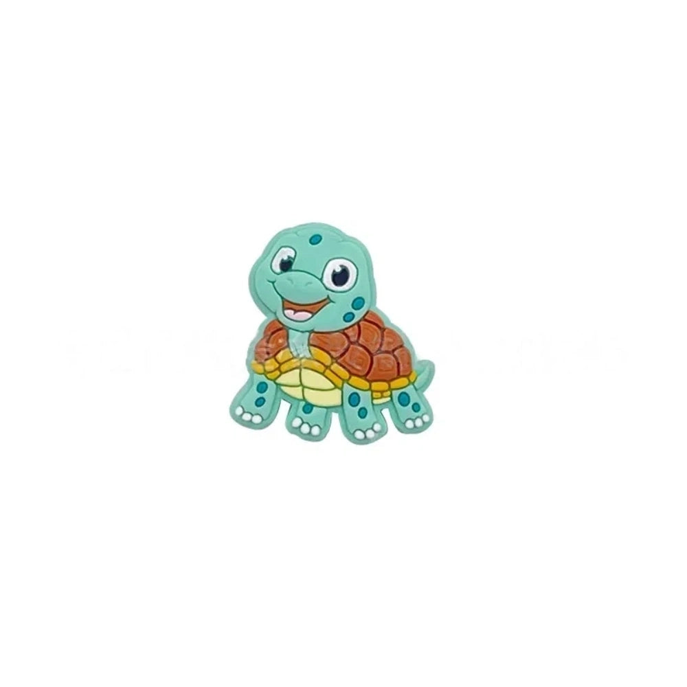 Cartoon turtle silicone focal beads in green, blue, yellow, and pink colors displayed on white pedestals against a pink background, available in large and small sizes for DIY crafts. - Mint green