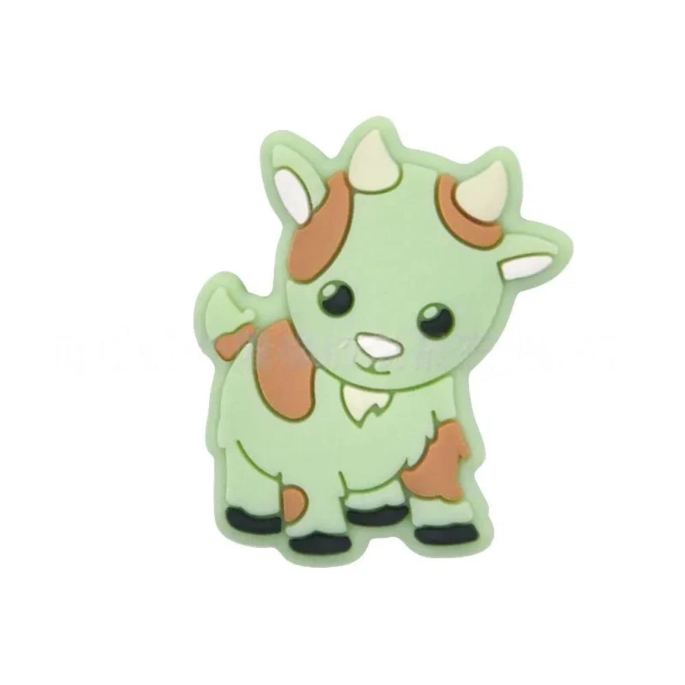 Assorted pastel color cute cow silicone focal beads displayed on a white shell dish and strung on a white cord against a teal background, available in gray, green, pink, tan, and white colorways. - Green