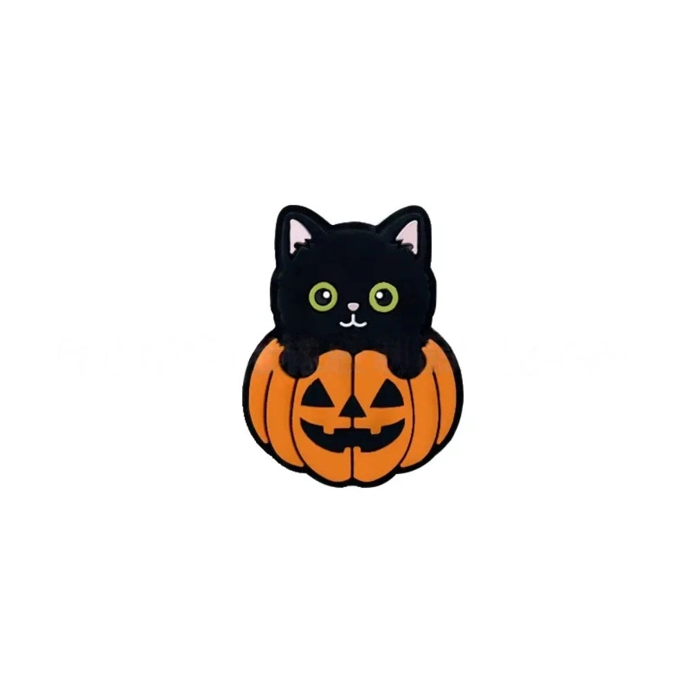 Three Halloween black cat sitting in jack-o-lantern pumpkin silicone focal beads displayed on a peach background, showing orange and black 3D character design. - Green Eye