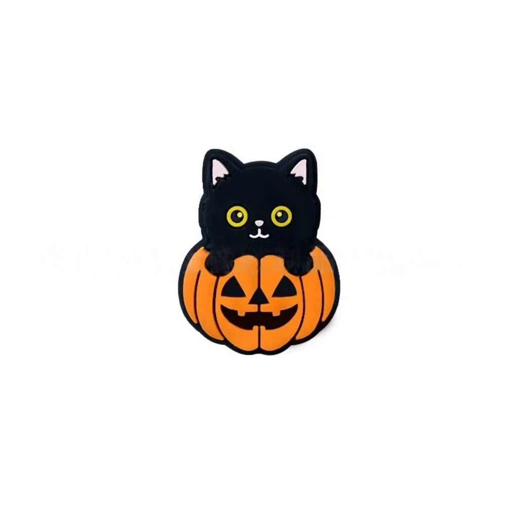 Three Halloween black cat sitting in jack-o-lantern pumpkin silicone focal beads displayed on a peach background, showing orange and black 3D character design. - Yellow Eye