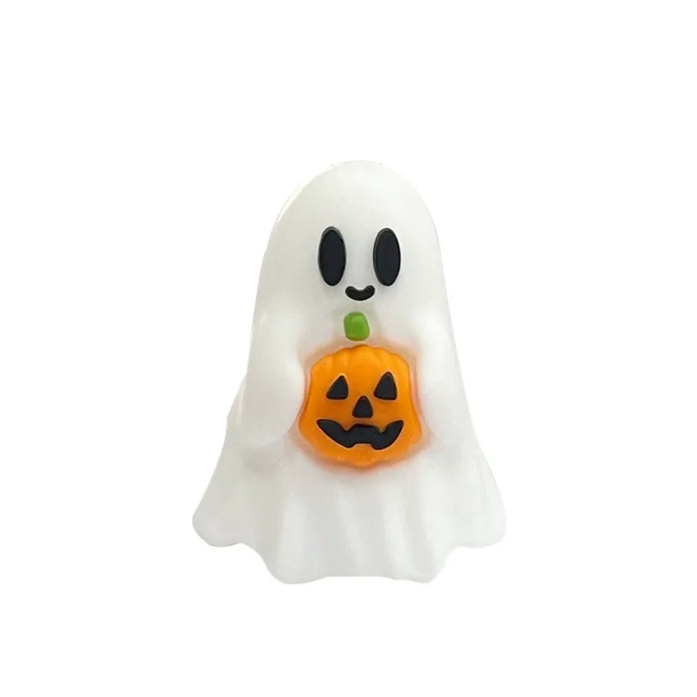 Three white Halloween ghost silicone focal beads – two holding jack-o-lantern pumpkins and one with a pink bow and heart – displayed in front of a white ceramic bowl on a beige surface. - 1