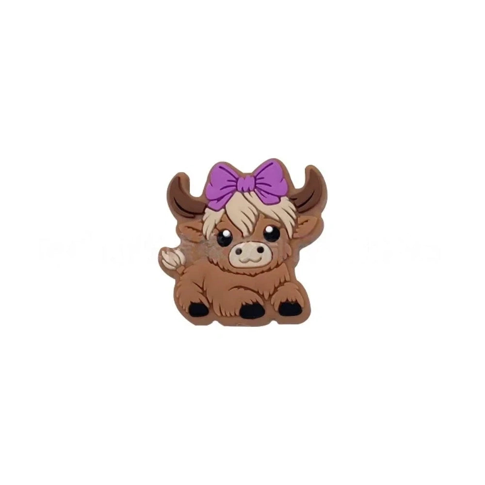 Six silicone Highland cow focal beads in brown – three wearing colorful baseball caps (blue, teal, gray) and three with bow accessories (mint, purple, pink) – crafting supplies for beadable pens, keychains, and badge reels. - Purple