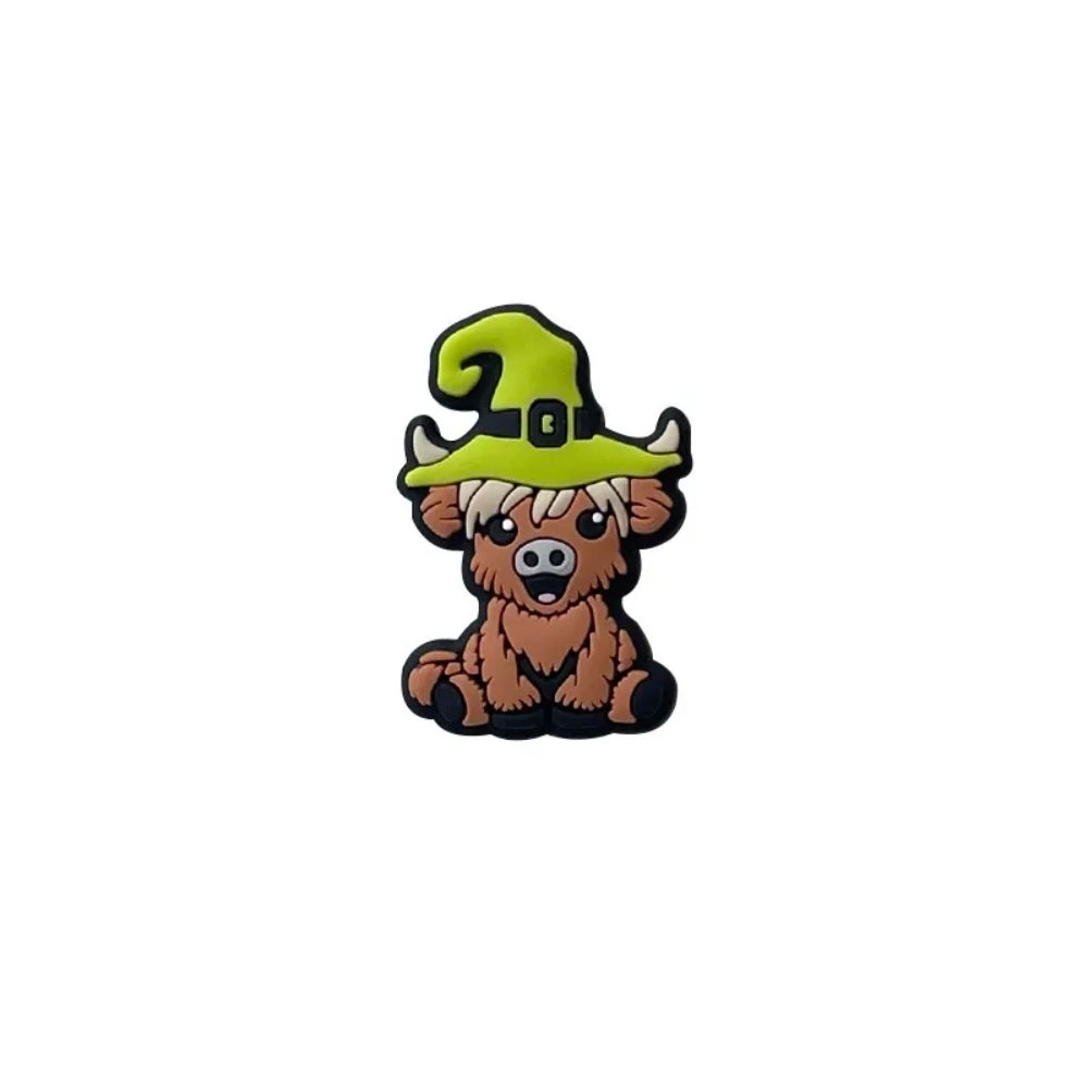 Four 3D silicone focal beads shaped like cartoon highland cows wearing witch hats in pink, yellow-green, purple, and dark purple, displayed on a white tray with a beadable pen. - Green